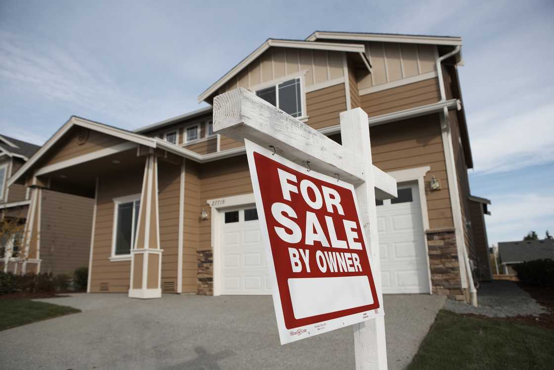 A 'For Sale' sign in front of a house