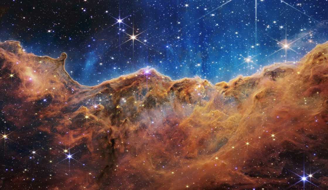 This image from the James Webb Space Telescope shows “mountains” and “valleys” speckled with glittering stars which is actually the edge of a nearby, young, star-forming region called NGC 3324 in the Carina Nebula