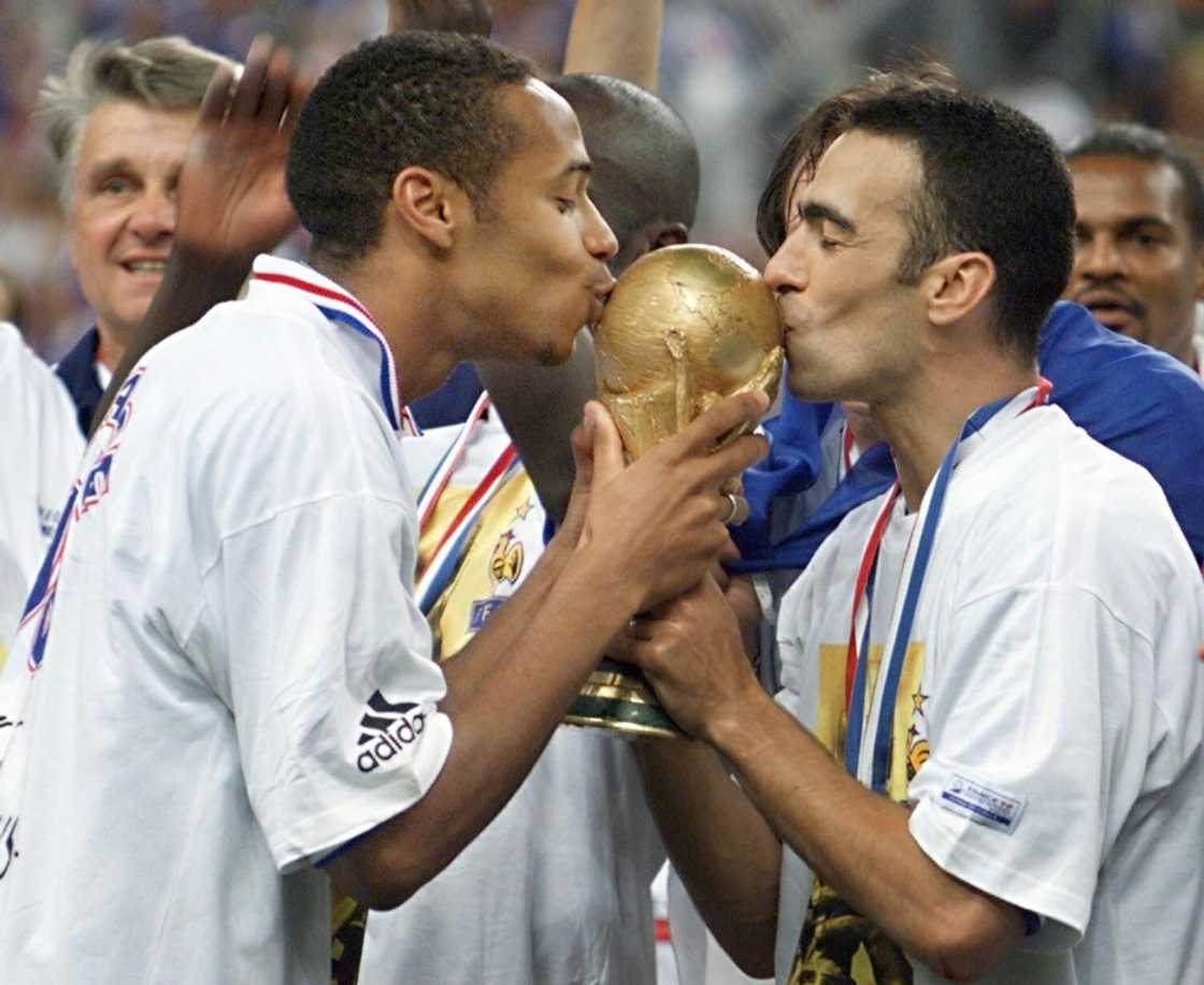 French football legend Thierry Henry (L) and Youri Djorkaeff kiss the World Cup trophy after France won it at Stade de France in 1998 French football legend Thierry Henry (L) and Youri Djorkaeff kiss the World Cup trophy after France won it at Stade de France in 1998