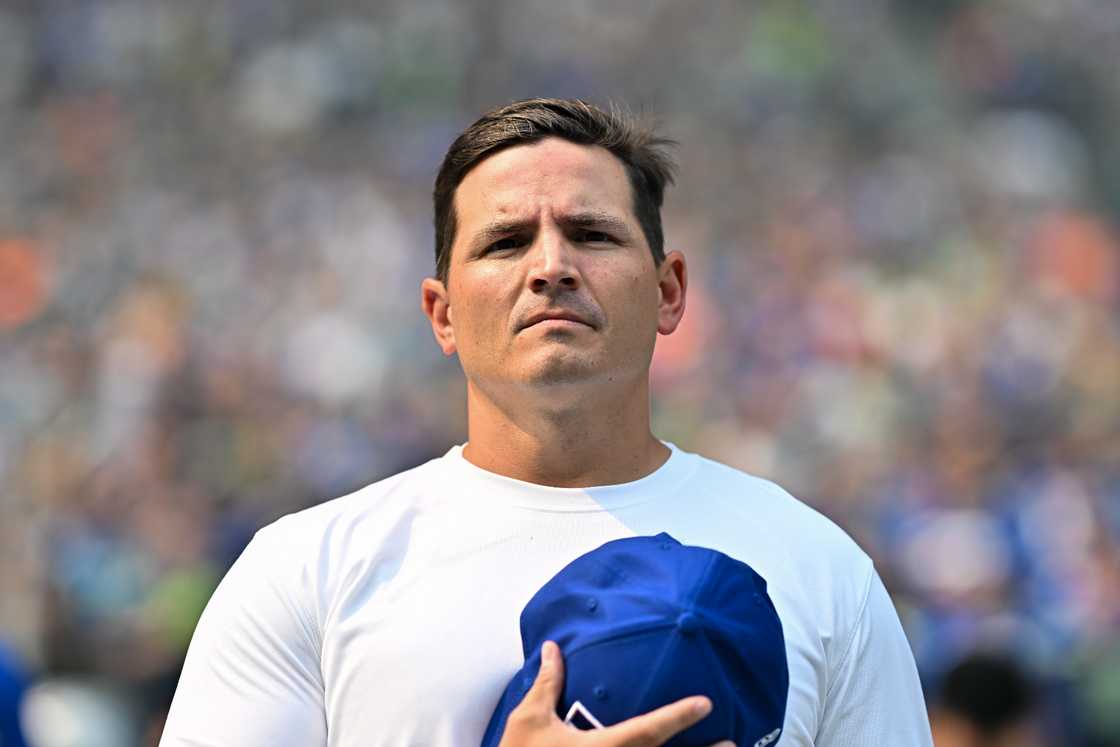 Mike Macdonald stands on the sideline while playing the National Anthem