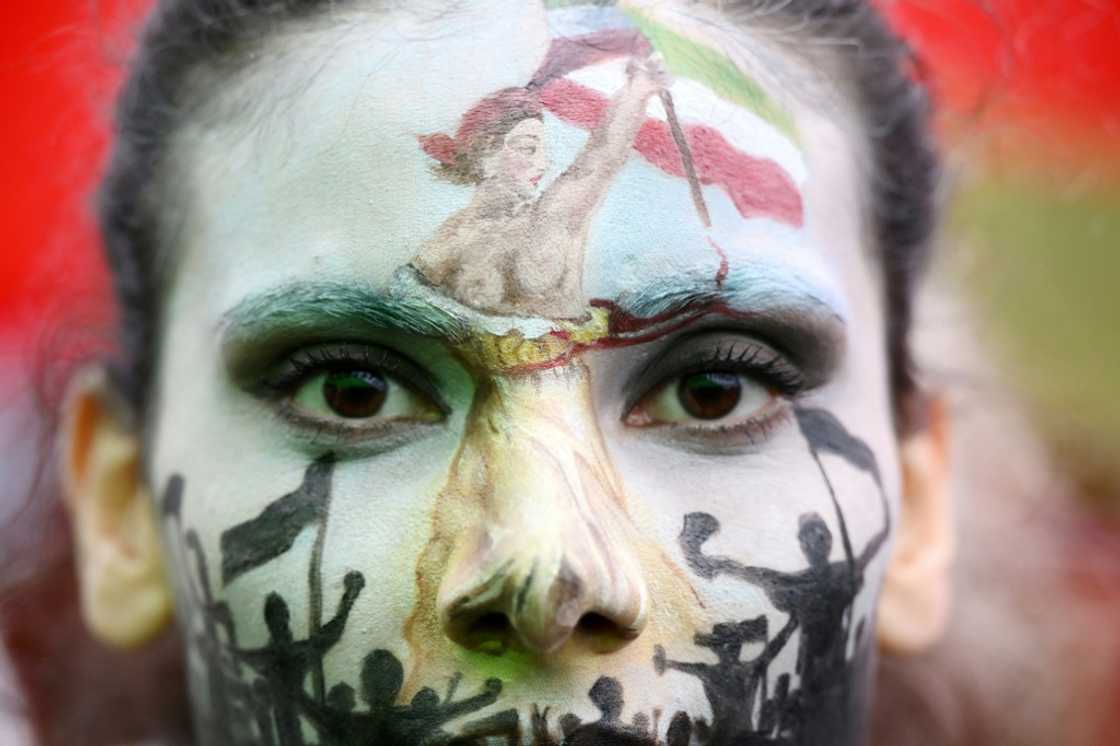 A protester wearing face-paint depicting France's iconic "Marianne" leading an uprising, attends a demonstration in support of Kurdish woman Mahsa Amini on October 2 in Paris A protester wearing face-paint depicting France's iconic "Marianne" leading an uprising, attends a demonstration in support of Kurdish woman Mahsa Amini on October 2 in Paris