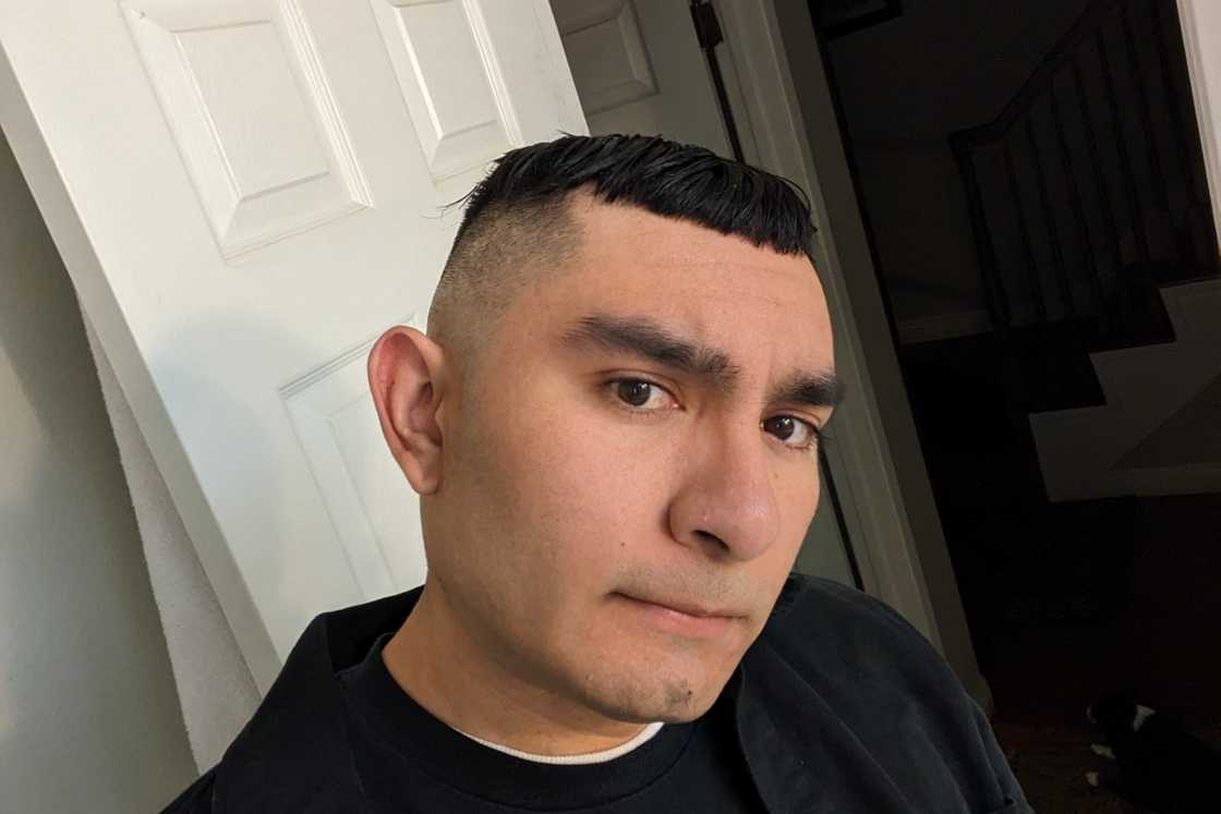 A black-haired man is rocking a Caesar cut with a high fade A black-haired man is rocking a Caesar cut with a high fade