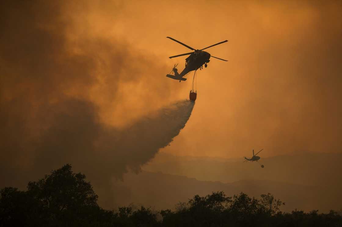 National Guard helicopters fight a wildfire in California; the rising number of such fires in the United States is increasing demands on troops