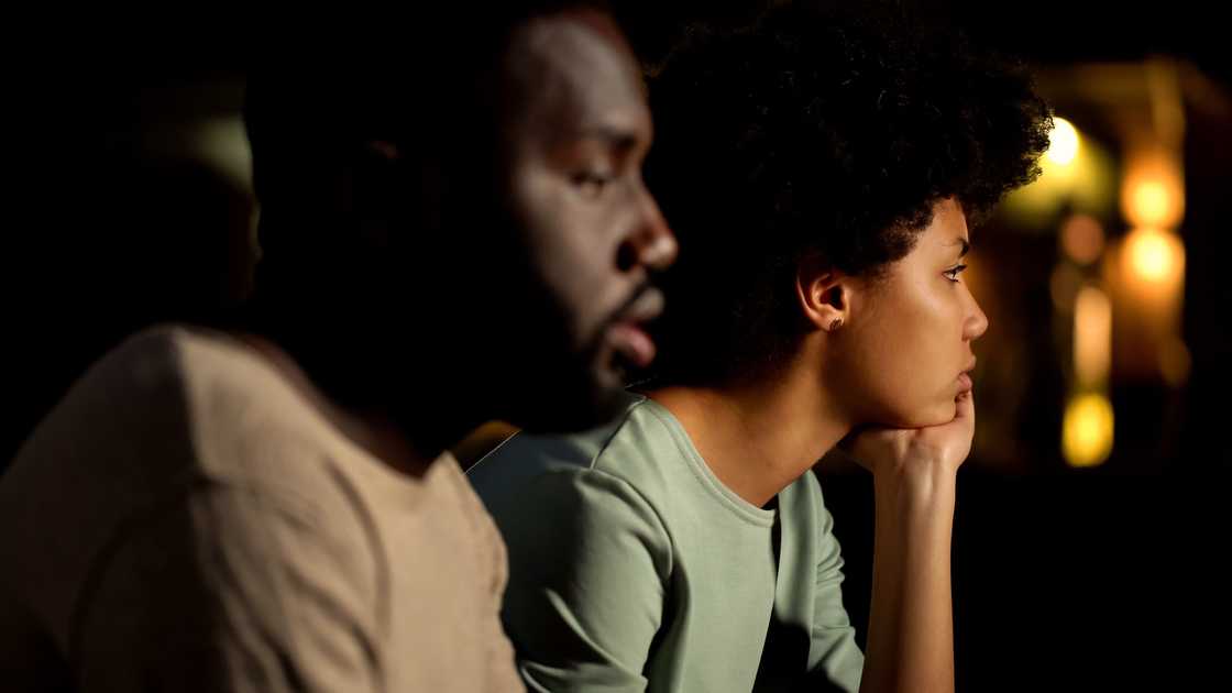 A worried couple in a dark room