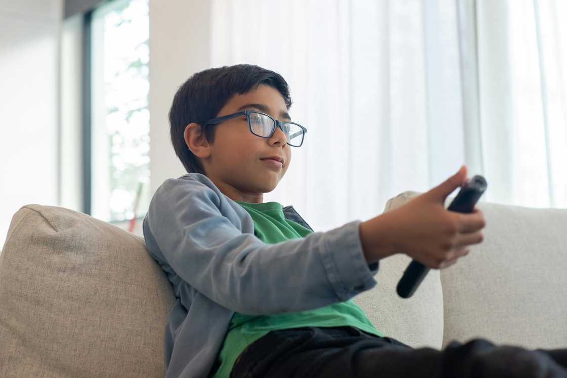 A boy holding a remote control A boy holding a remote control