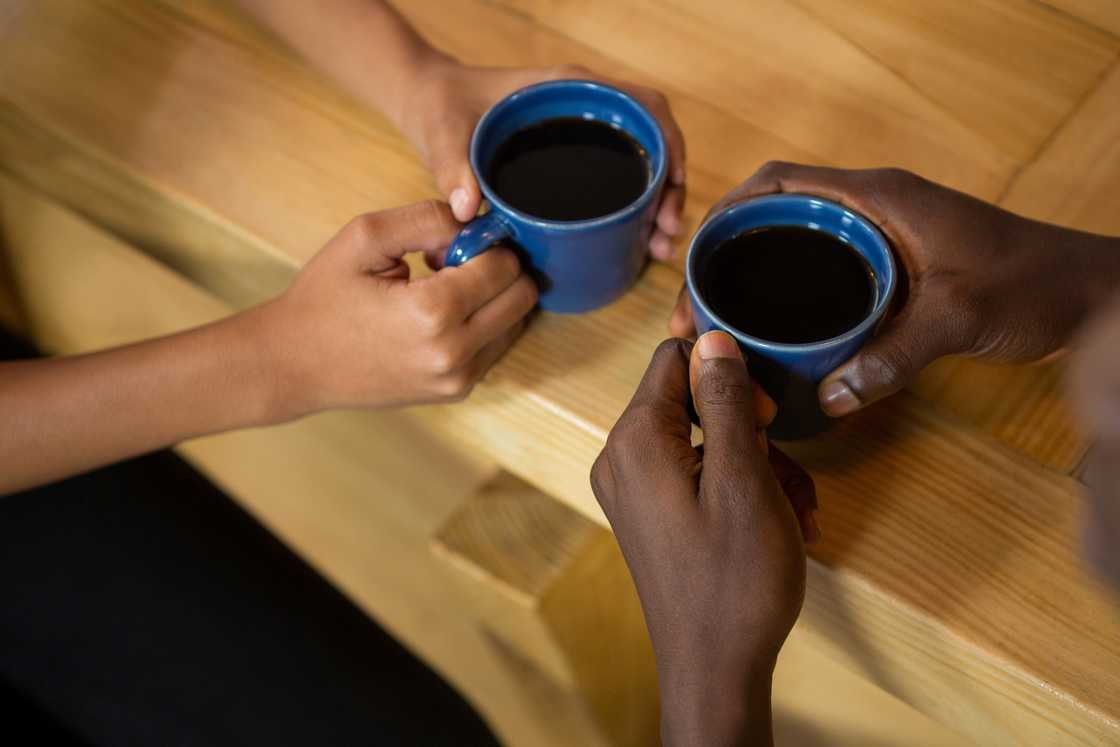Close-up of hands around a coffee mug.