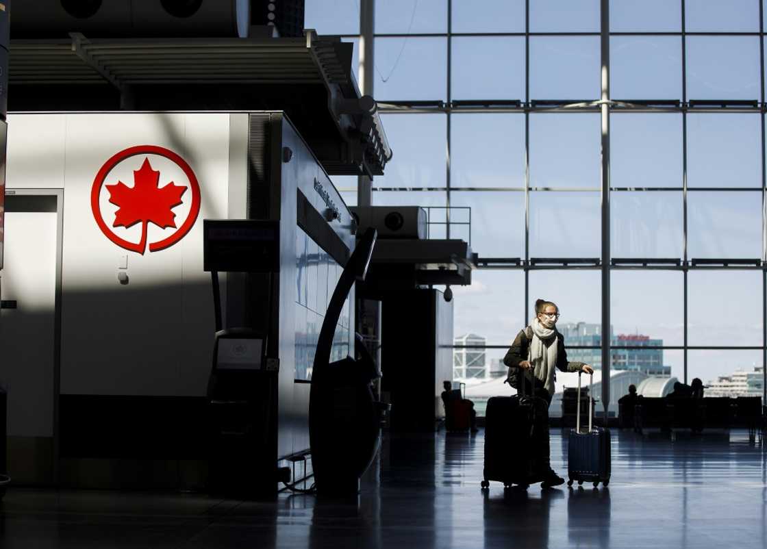 A passenger wheels her luggage near an Air Canada logo at Toronto Pearson International Airport in April 2020 A passenger wheels her luggage near an Air Canada logo at Toronto Pearson International Airport in April 2020