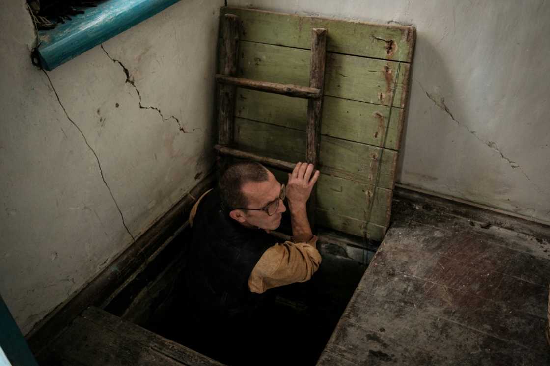 Ivan Lobachov emerges from a cellar used as a shelter, in the family house which was partially destroyed by shelling Ivan Lobachov emerges from a cellar used as a shelter, in the family house which was partially destroyed by shelling