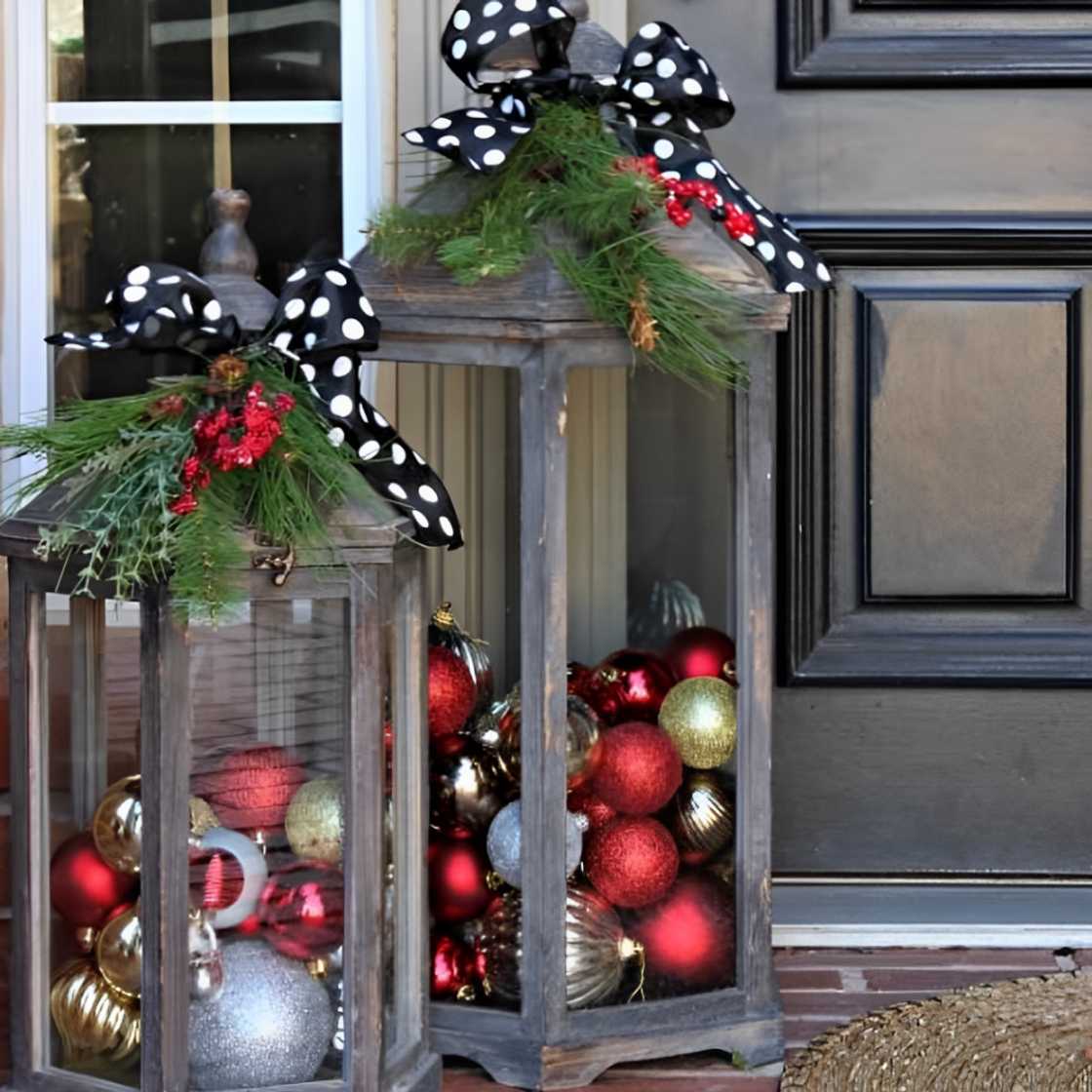 A front porch featuring lanterns filled with ornaments