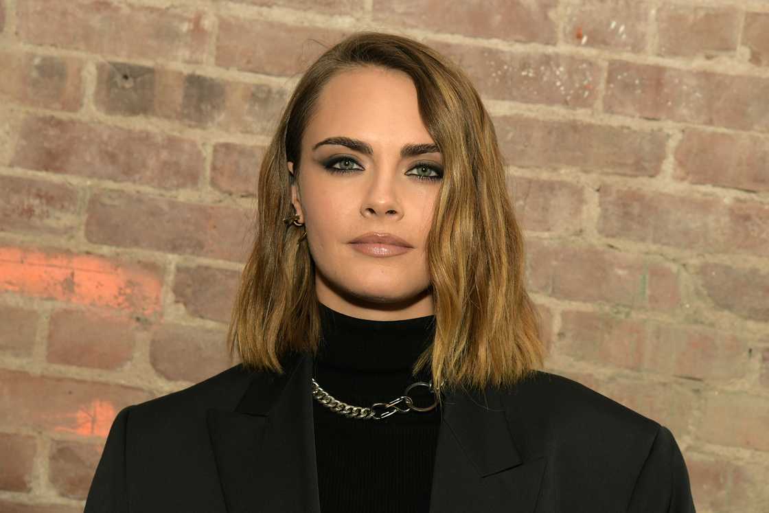 Cara Delevingne stands next to a wall in New York City, New York Cara Delevingne stands next to a wall in New York City, New York