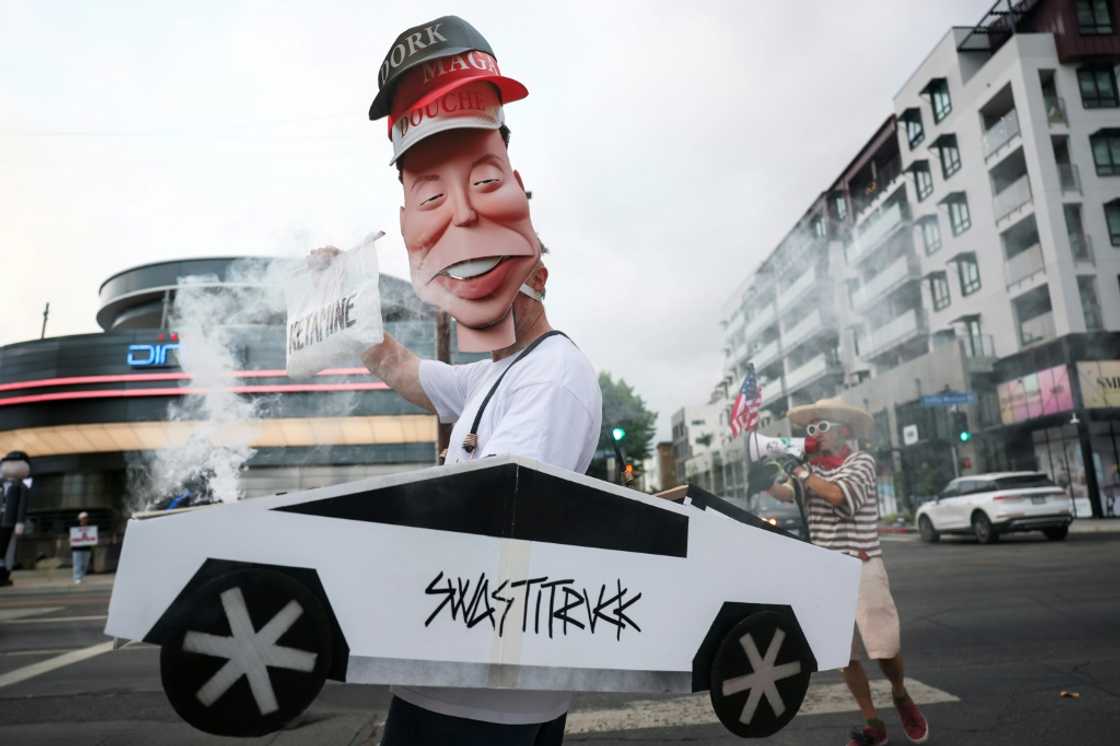 Demonstrators held signs during the 'Tyrant Diner' protest last month against Elon Musk outside of the Tesla Diner and Drive-In Restaurant and Supercharger in Los Angeles