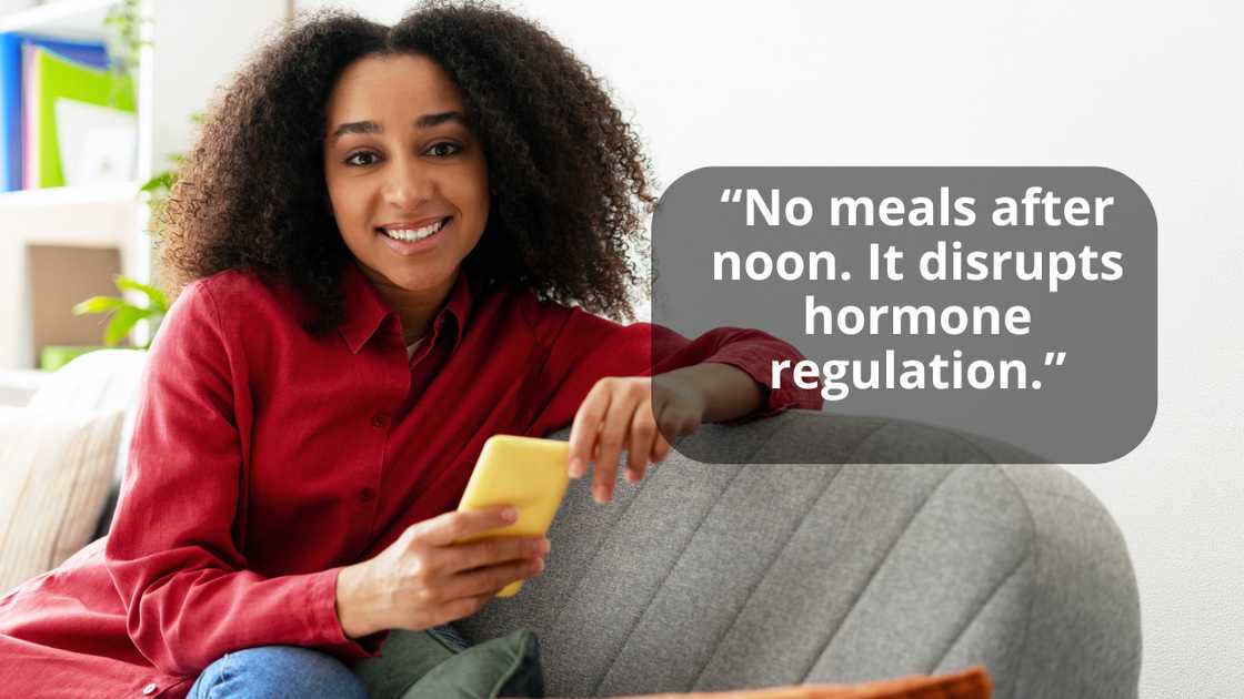 A woman holding mobile phone while sitting on sofa at home A woman holding mobile phone while sitting on sofa at home