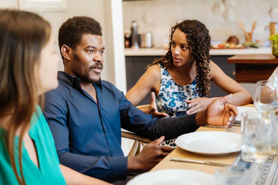 A woman confronts a man during dinner.