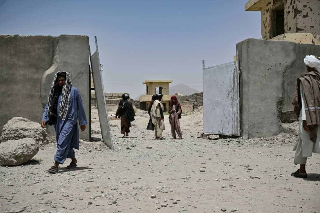 Afghans gather at the entrance of the ramshackle Musa Qala District Hospital in Helmand province in July 2022 amid widespread needs in the war-ravaged country again under Taliban rule