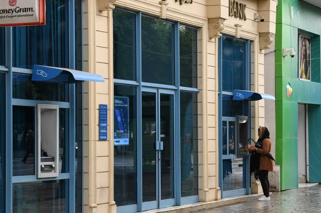 A woman withdraws money from an ATM on in Tunis A woman withdraws money from an ATM on in Tunis
