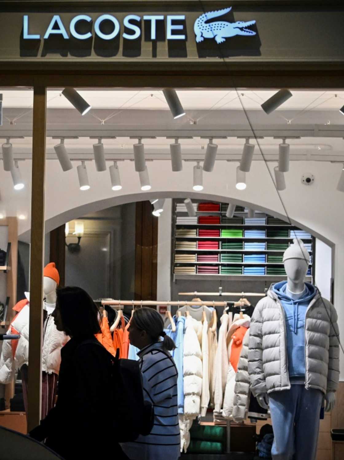 Customers walk past a French Lacoste shop at the GUM department store in Moscow