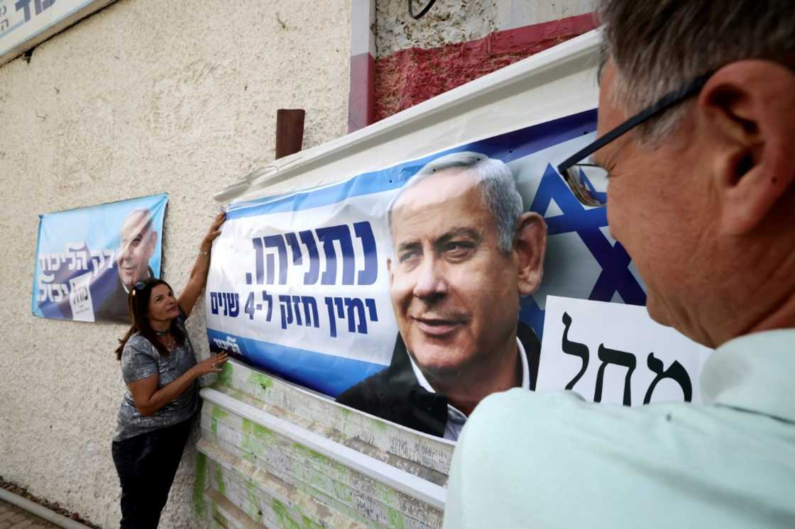 Israelis hang a poster of Likud party Benjamin Netanyahu in the southern city of Beersheva, on October 25, 2022 ahead of Israel's November 1 election Israelis hang a poster of Likud party Benjamin Netanyahu in the southern city of Beersheva, on October 25, 2022 ahead of Israel's November 1 election