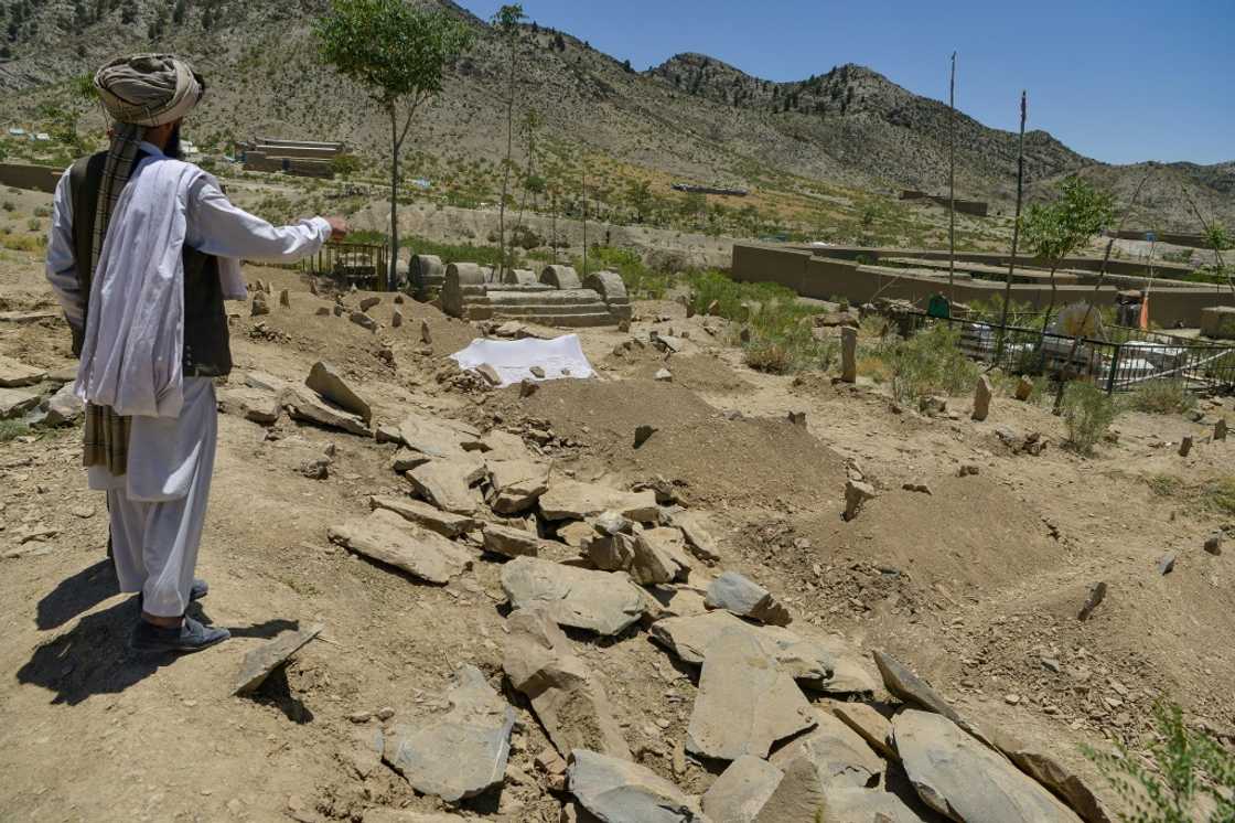 A villager looks over freshly dug graves containing victims of the deadly Afghan earthquake in Gayan district A villager looks over freshly dug graves containing victims of the deadly Afghan earthquake in Gayan district