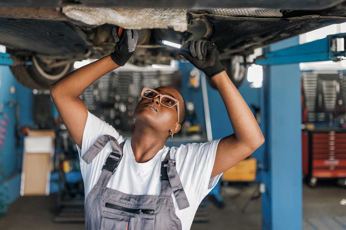 A female mechanic checking a vehicle A female mechanic checking a vehicle