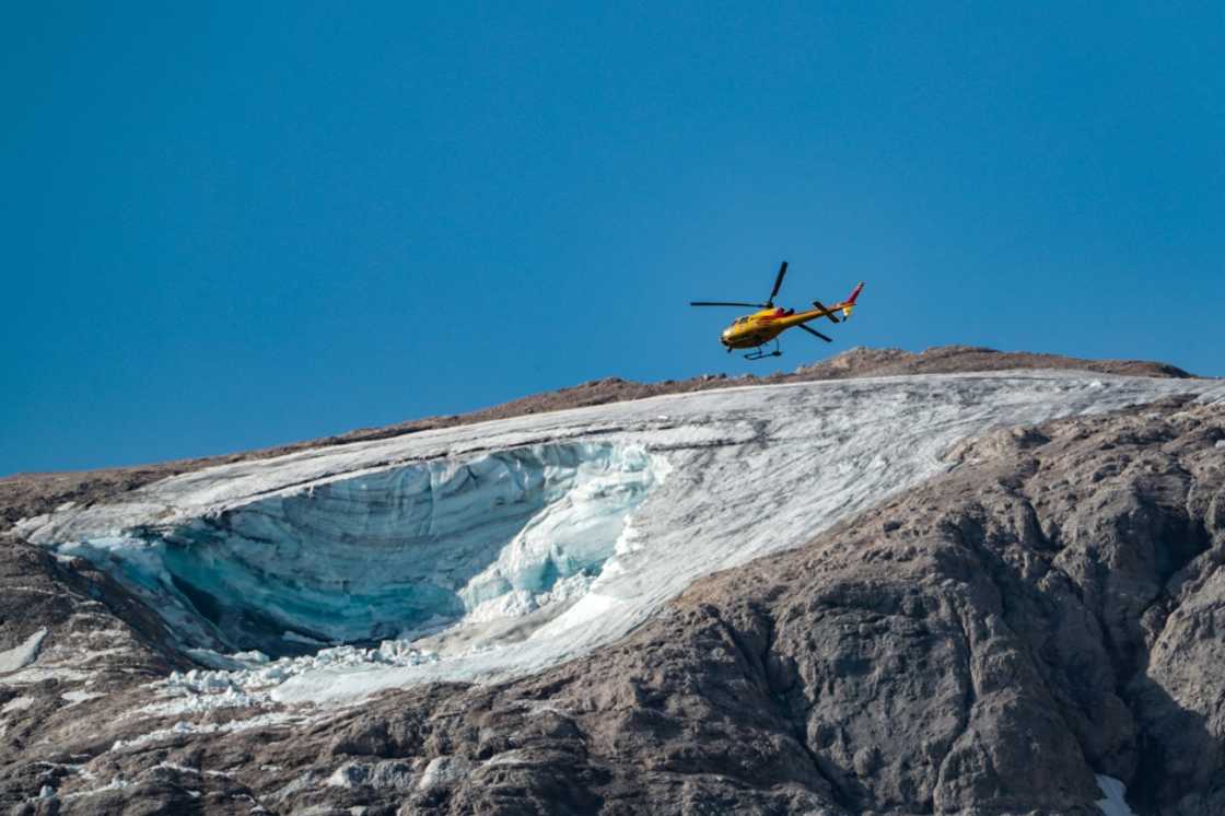 A rescue helicopter flies over the partially collapsed glacier on Marmolada, the highest mountain in the Dolomites A rescue helicopter flies over the partially collapsed glacier on Marmolada, the highest mountain in the Dolomites