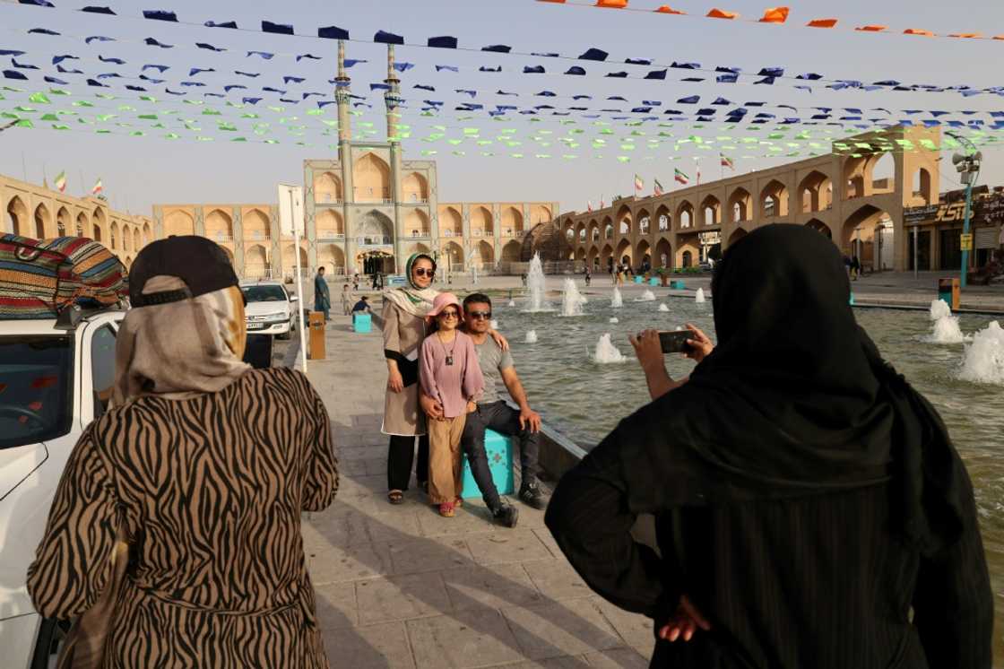 People pose for a photo before the medieval Timurid-era mosque of Amir Chakhmaq (also known as Dahouk mosque), completed in 1438, in Yazd in central Iran on July 4, 2023 People pose for a photo before the medieval Timurid-era mosque of Amir Chakhmaq (also known as Dahouk mosque), completed in 1438, in Yazd in central Iran on July 4, 2023