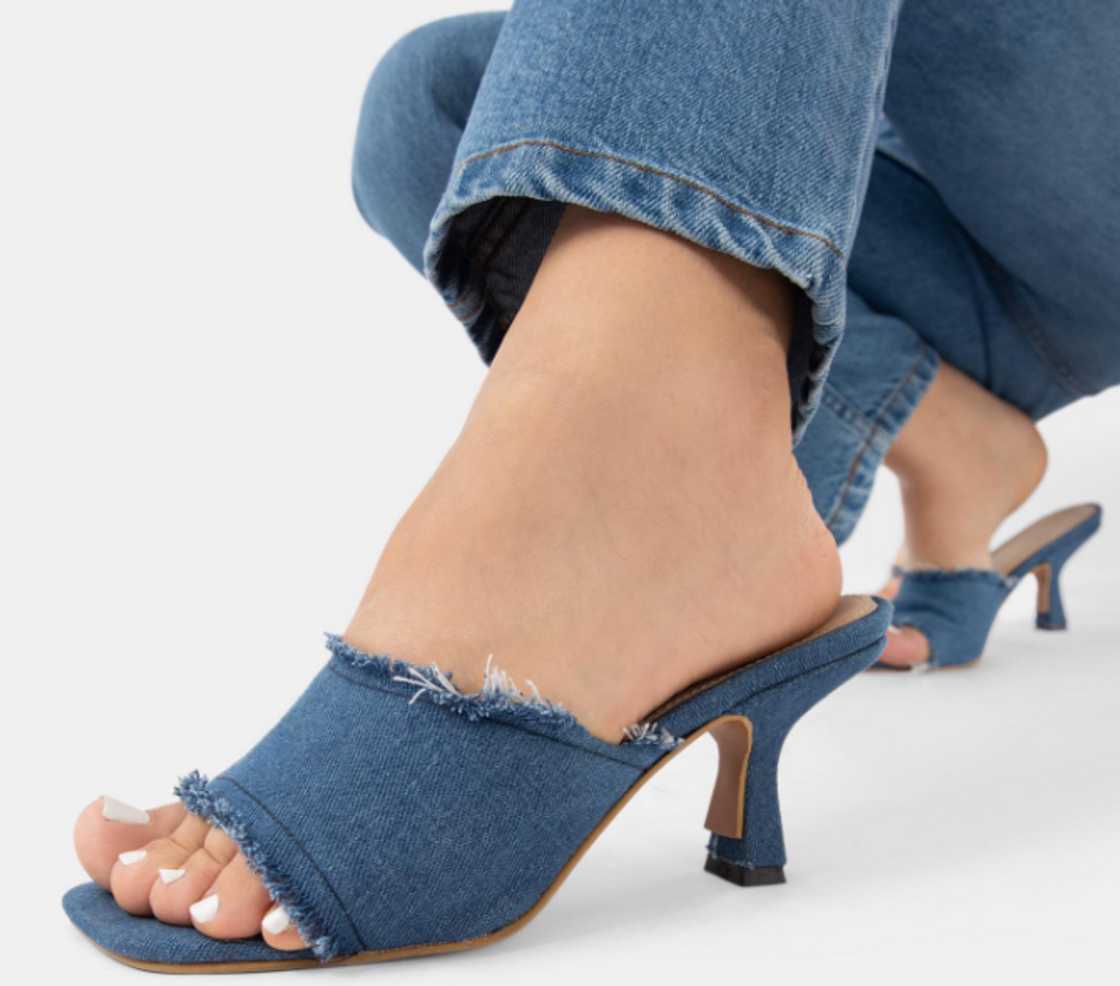 A woman with a pair of heeled mules A woman with a pair of heeled mules