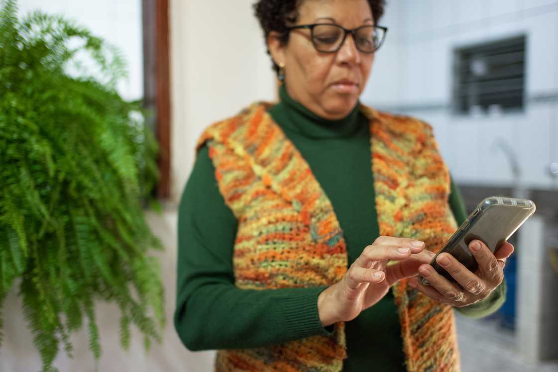 A senior woman uses a smartphone.