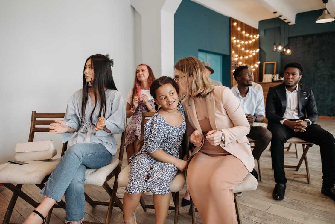 People sit on chairs during a small church gathering. People sit on chairs during a small church gathering.
