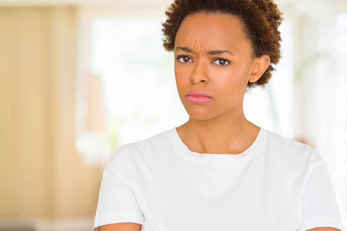 A young woman looking nervous with crossed arms