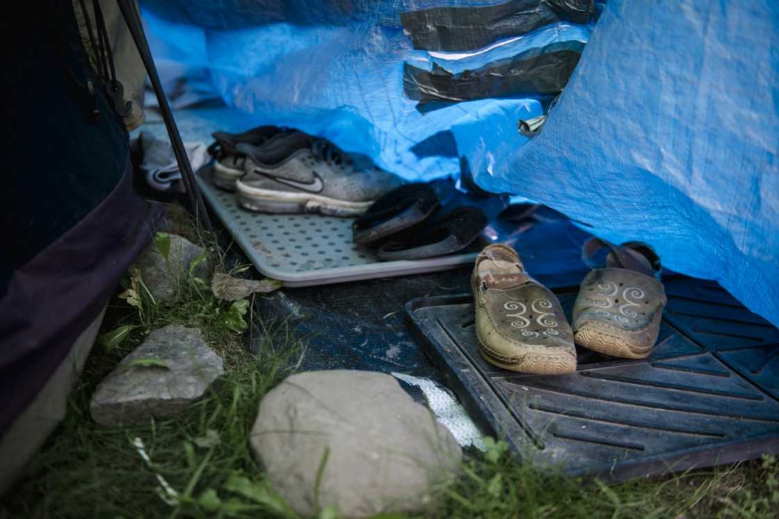 Shoes belonging to a woman are left just outside her tent in a makeshift homeless encampment in a park in Granby, Canada Shoes belonging to a woman are left just outside her tent in a makeshift homeless encampment in a park in Granby, Canada