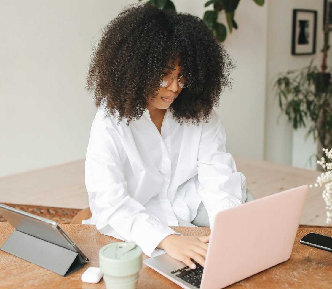A serious woman typing something on her laptop