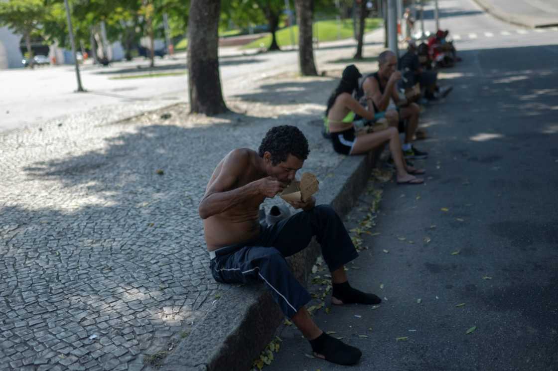 A homeless man eats a meal donated by Brazilian chef Carlos Alberto da Silva, known as Nego Breu, and his team in the Lapa neighborhood in Rio de Janeiro