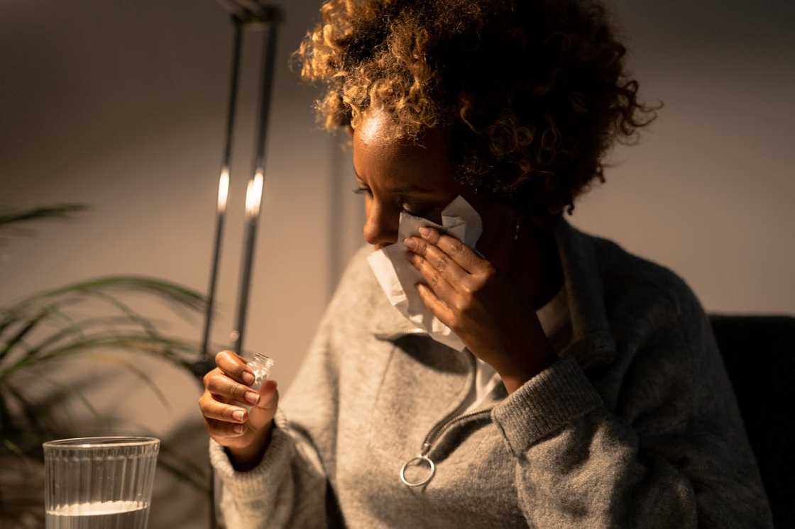 A woman crying while holding a tissue in her hands.