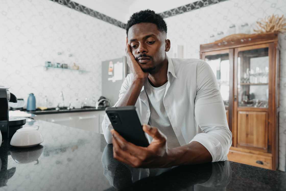 A sad man using a smartphone