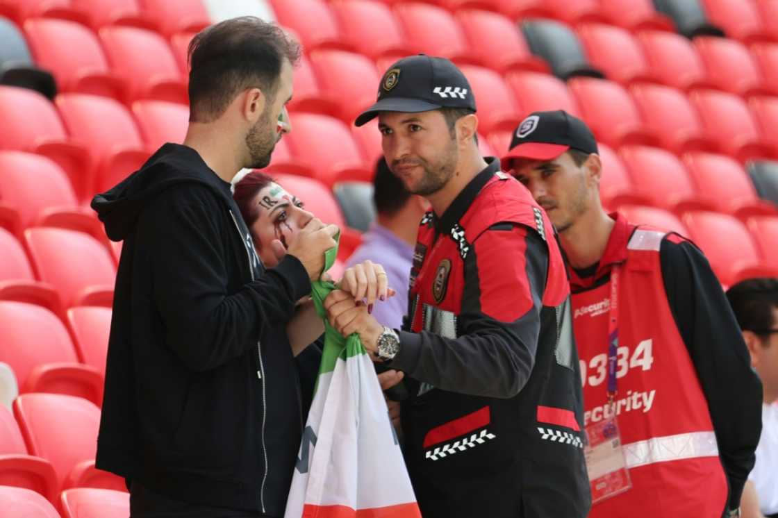 Members of security (R) speak with two Iran supporters, as they take away a flag reading "Woman life freedom", prior to the match between Wales and Iran last week Members of security (R) speak with two Iran supporters, as they take away a flag reading "Woman life freedom", prior to the match between Wales and Iran last week