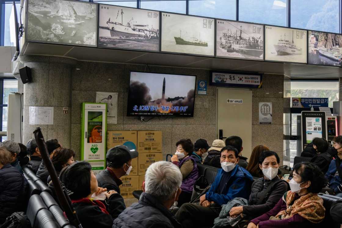 A Friday news broadcast shows file footage of a North Korean missile test as visitors wait at the ferry terminal for South Korea's eastern island of Ulleungdo A Friday news broadcast shows file footage of a North Korean missile test as visitors wait at the ferry terminal for South Korea's eastern island of Ulleungdo