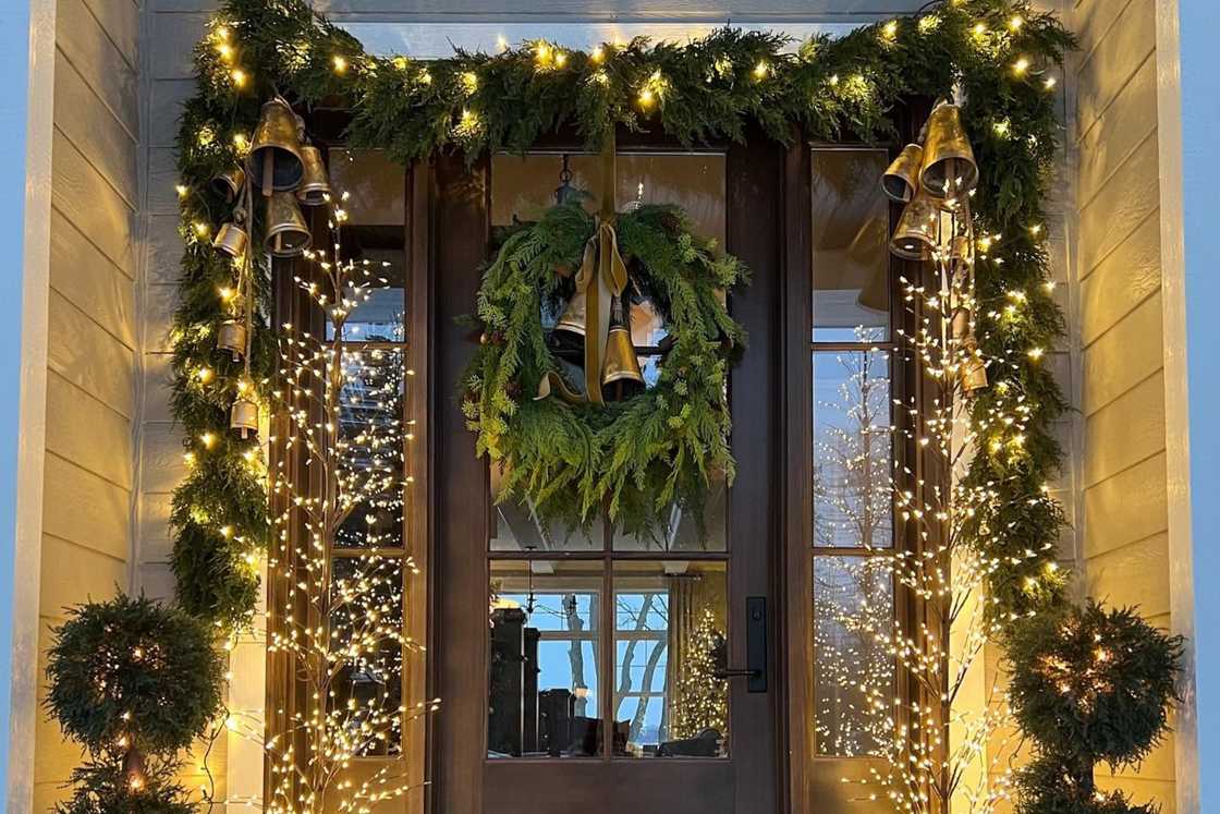 A twinkling entrance with a wreath hanging on the door