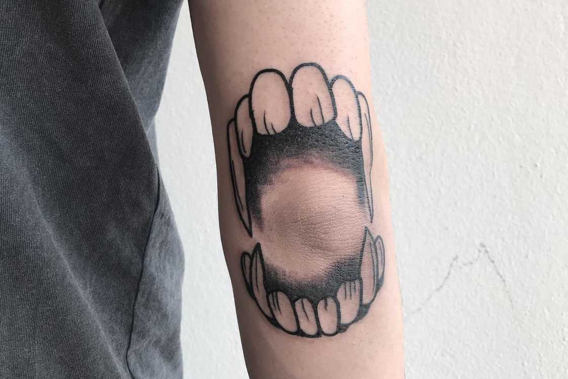 A black and white teeth elbow tattoo A black and white teeth elbow tattoo