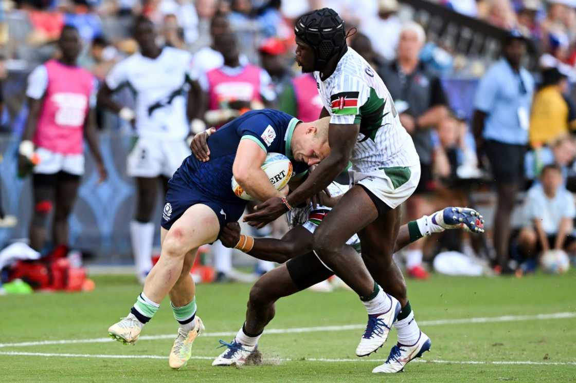 Kenya's Willy Ambaka (C) and Vincent Onyala (R) tackle Scotland's Reiss Cullen in the World Rugby Sevens Series event in Carson, California on August 27, 2022. Kenya's Willy Ambaka (C) and Vincent Onyala (R) tackle Scotland's Reiss Cullen in the World Rugby Sevens Series event in Carson, California on August 27, 2022.