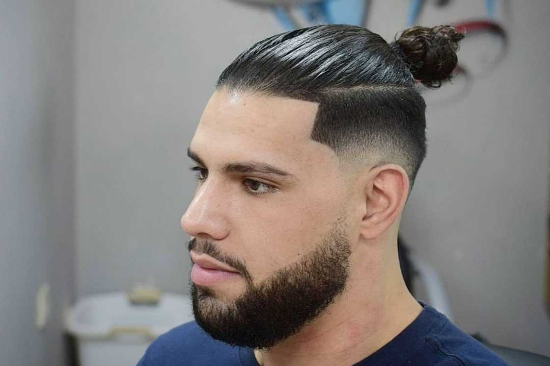 A nice blend of a man bun with a short fade and a beard A nice blend of a man bun with a short fade and a beard