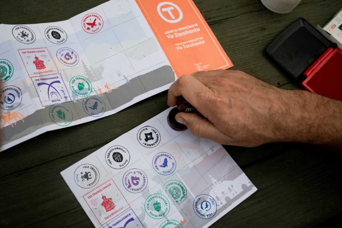 A hiker on the Via Transilvanica receives a stamp in his 'passport' for having completed a stage of the trail A hiker on the Via Transilvanica receives a stamp in his 'passport' for having completed a stage of the trail
