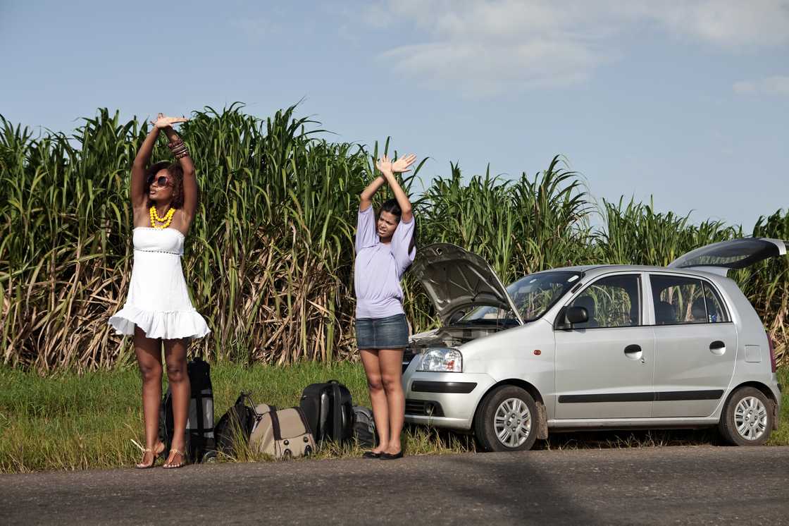 Two ladies are waiving their hands above their heads Two ladies are waiving their hands above their heads
