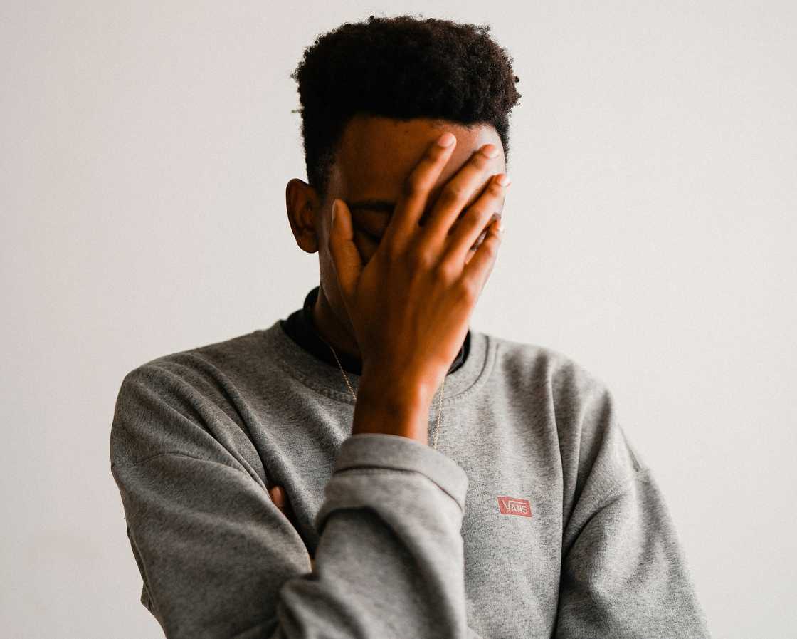 Dissapointed teen covering his face Dissapointed teen covering his face