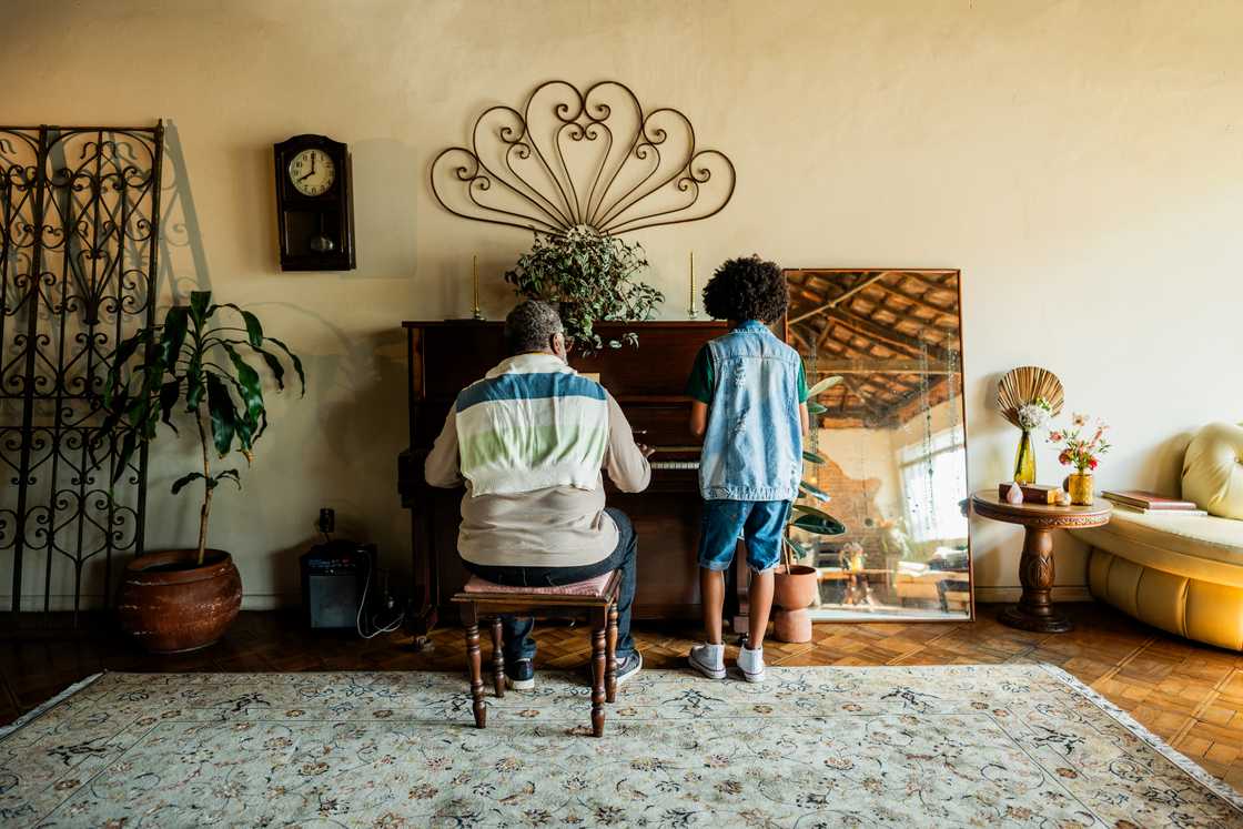 Grandfather playing the piano with his grandson Grandfather playing the piano with his grandson