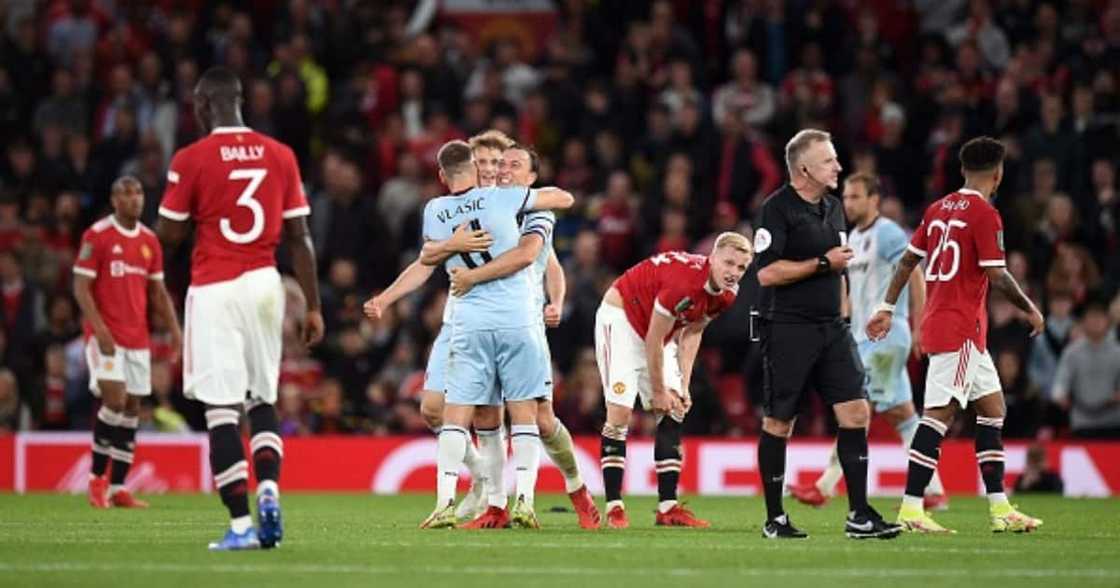 Manchester United players react as West Ham celebrate winning the English League Cup third round football match between Manchester United and West Ham United at Old Trafford in Manchester. (Photo by Oli SCARFF / AFP). Manchester United players react as West Ham celebrate winning the English League Cup third round football match between Manchester United and West Ham United at Old Trafford in Manchester. (Photo by Oli SCARFF / AFP).