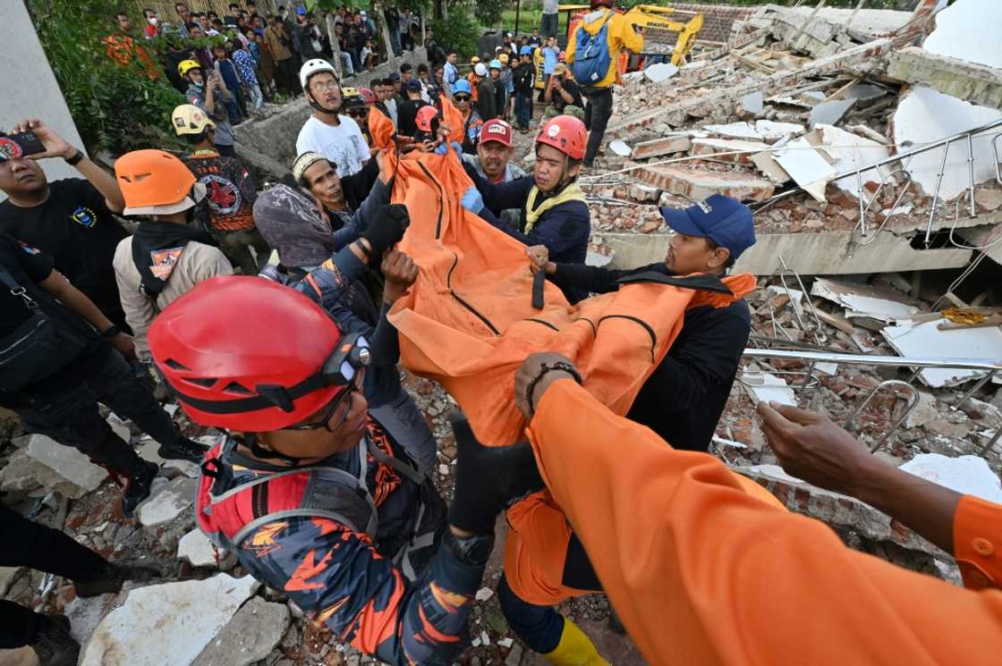 Rescue workers carry the body of a victim in Cianjur Rescue workers carry the body of a victim in Cianjur