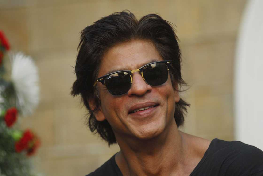 Shah Rukh Khan in a black tee and black sunglasses