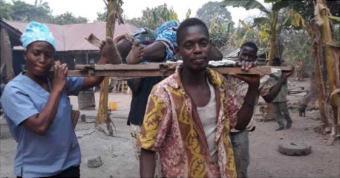 A/R: Expectant woman in labour carried on wooden board by nurse to distant clinic