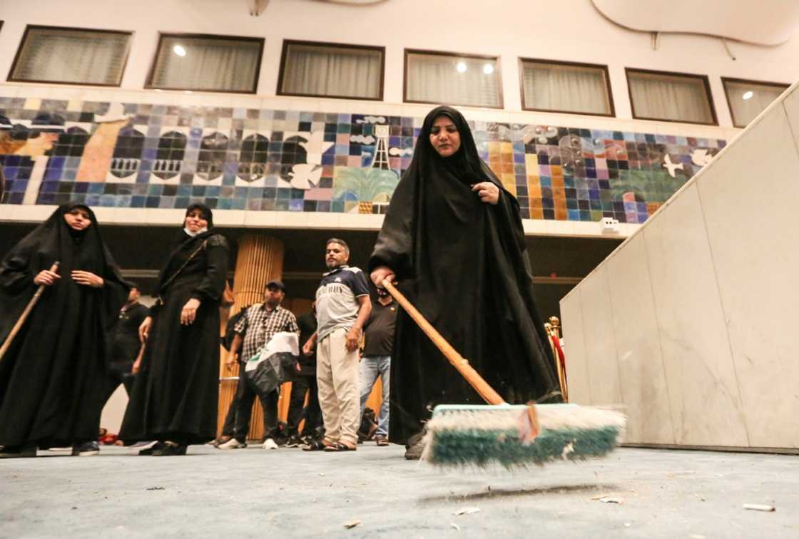 A woman sweeps the floor during the occupation of Iraq's parliament A woman sweeps the floor during the occupation of Iraq's parliament