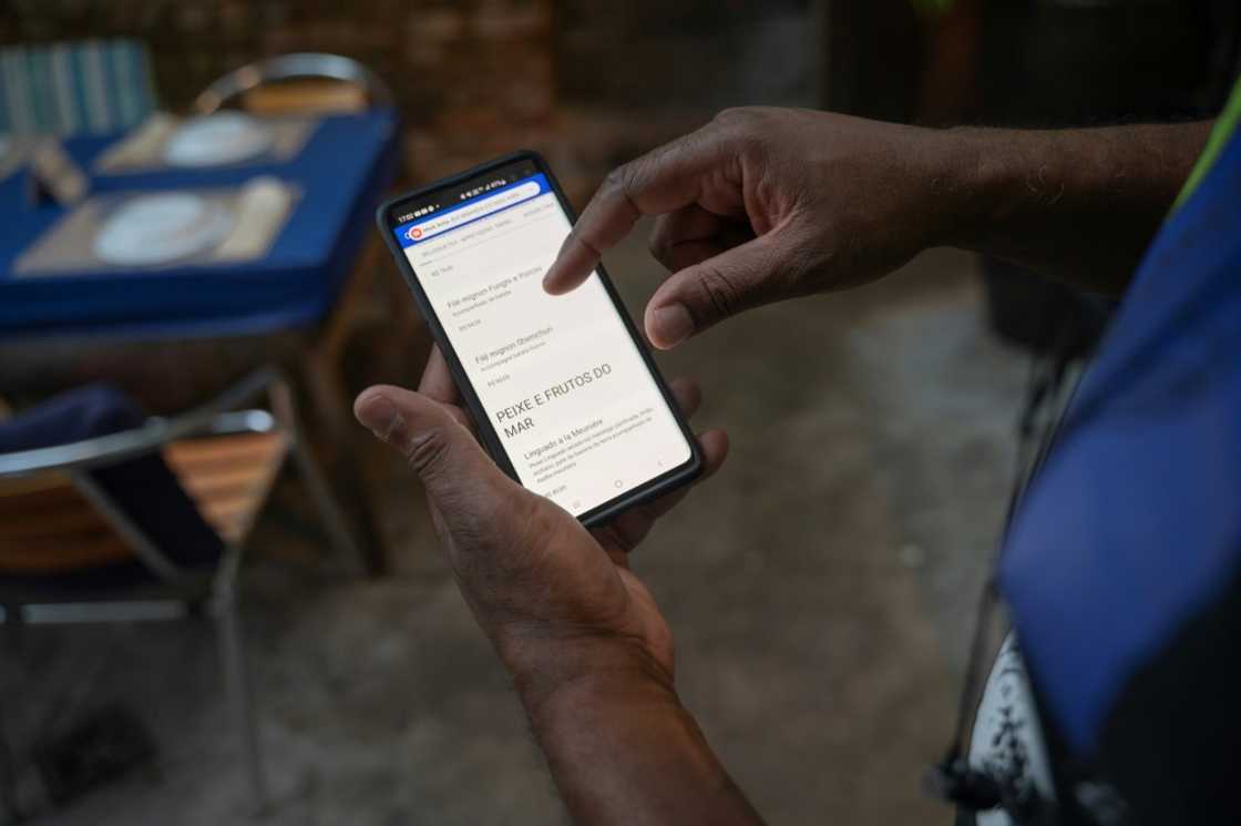 A worker shows a digital menu at Casa Nossa restaurant in the Lapa neighborhood in Rio de Janeiro, Brazil in May 2023. A worker shows a digital menu at Casa Nossa restaurant in the Lapa neighborhood in Rio de Janeiro, Brazil in May 2023.